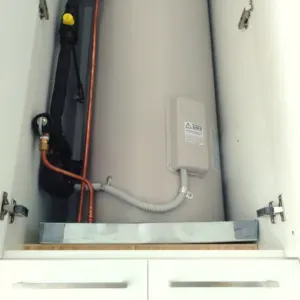 A Water Heater Is Sitting Inside Of A Cabinet — Nyblad Construction in Caloundra West, QLD