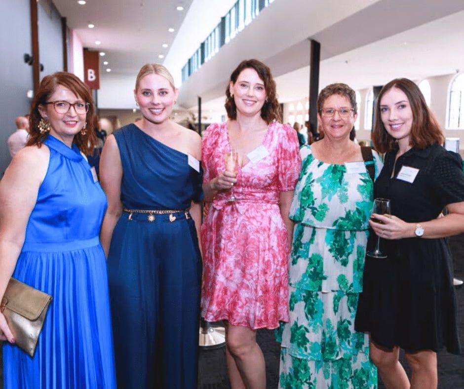 A Group of Women Are Posing for a Picture Together — Nyblad Construction in Caloundra West, QLD