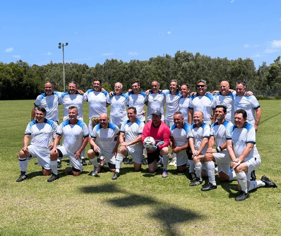 A Group of Men Are Posing for a Picture on a Soccer Field — Nyblad Construction in Caloundra West, QLD