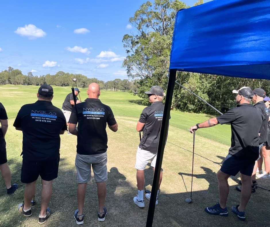 A Group of Men Are Standing on a Golf Course Holding Golf Clubs — Nyblad Construction in Caloundra West, QLD