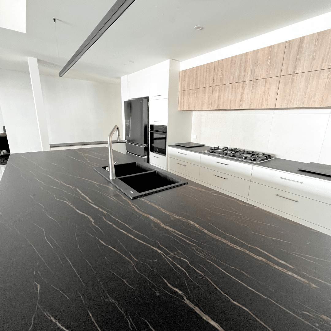 A Kitchen With A Black Counter Top — Nyblad Construction in Caloundra West, QLD