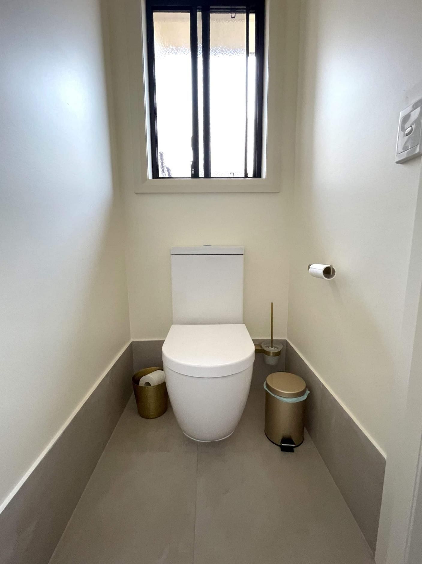 Toilet is Sitting in a Small Bathroom Next to a Window — Nyblad Construction in Caloundra West, QLD