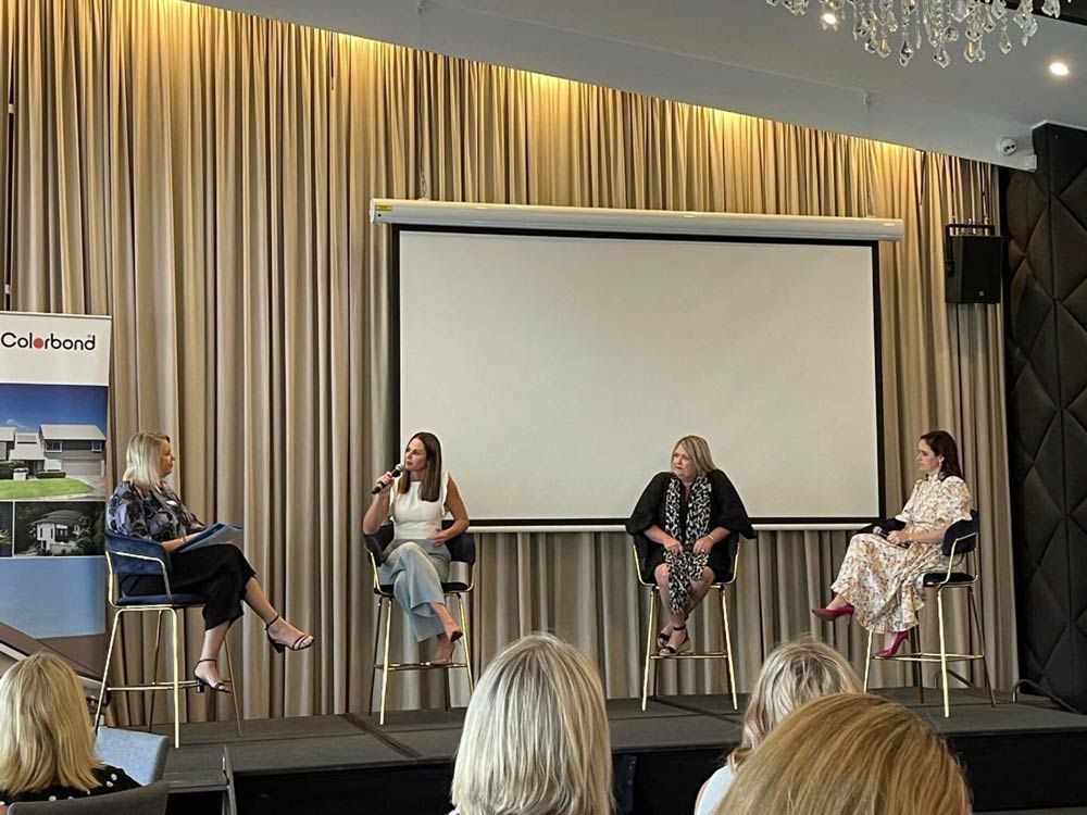 A Group Of Women Are Sitting On Stools In Front Of A Projector Screen — Nyblad Construction in Caloundra West, QLD