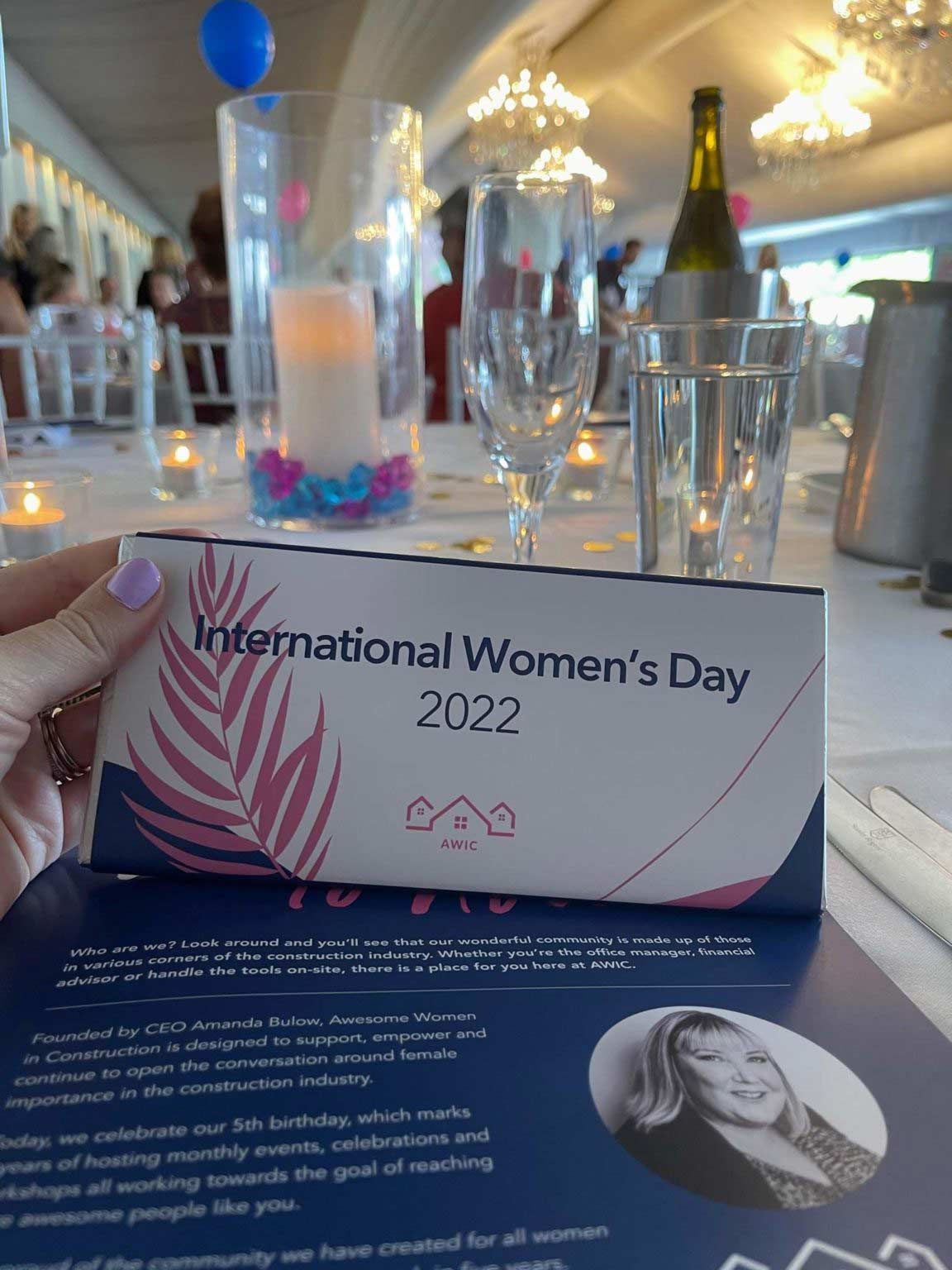 A Woman Is Holding A Sign For International Women 's Day 2022 — Nyblad Construction in Caloundra West, QLD