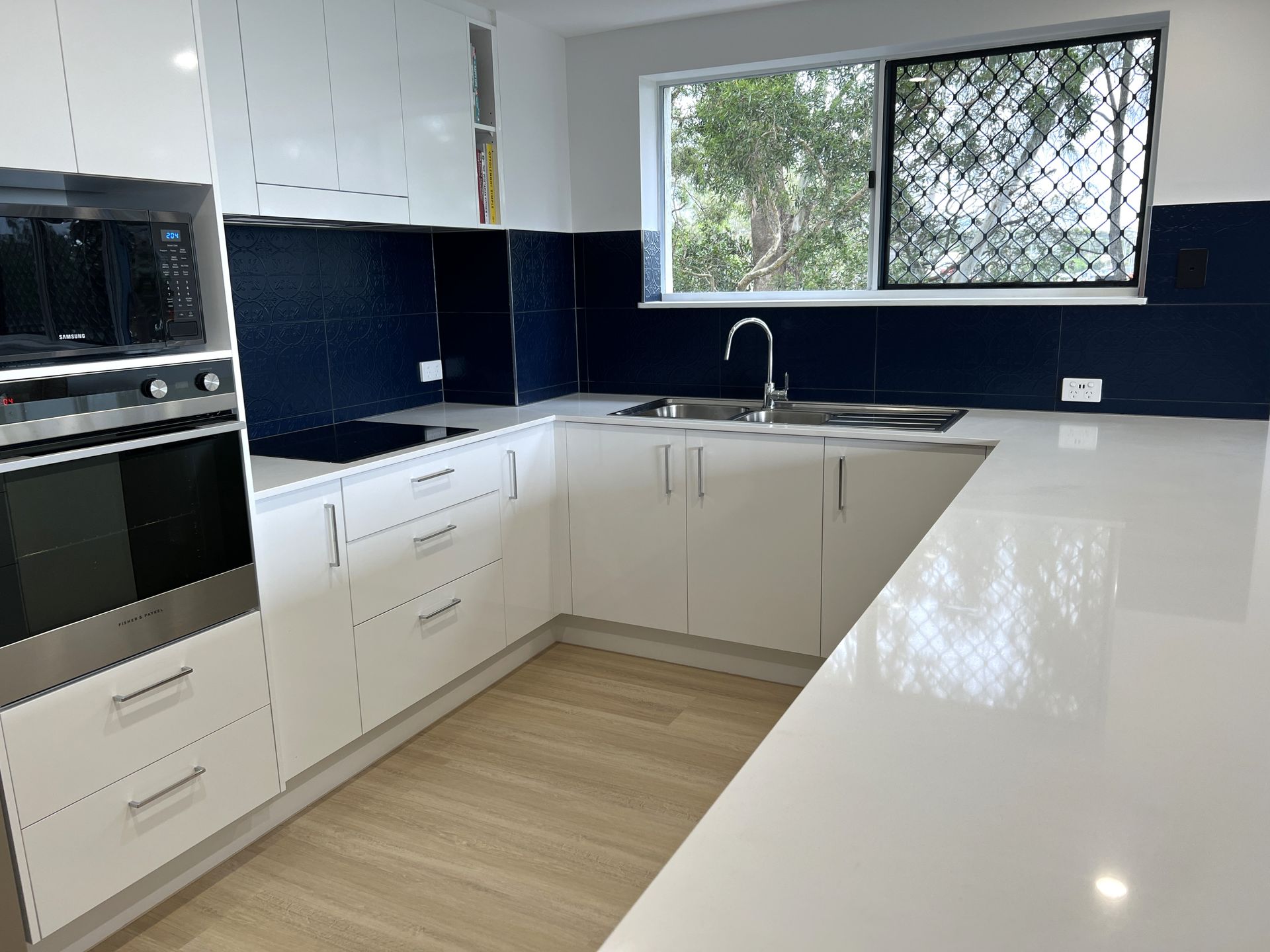 White and Navy Kitchen With Stainless Steel Appliances — Nyblad Construction in Caloundra West, QLD