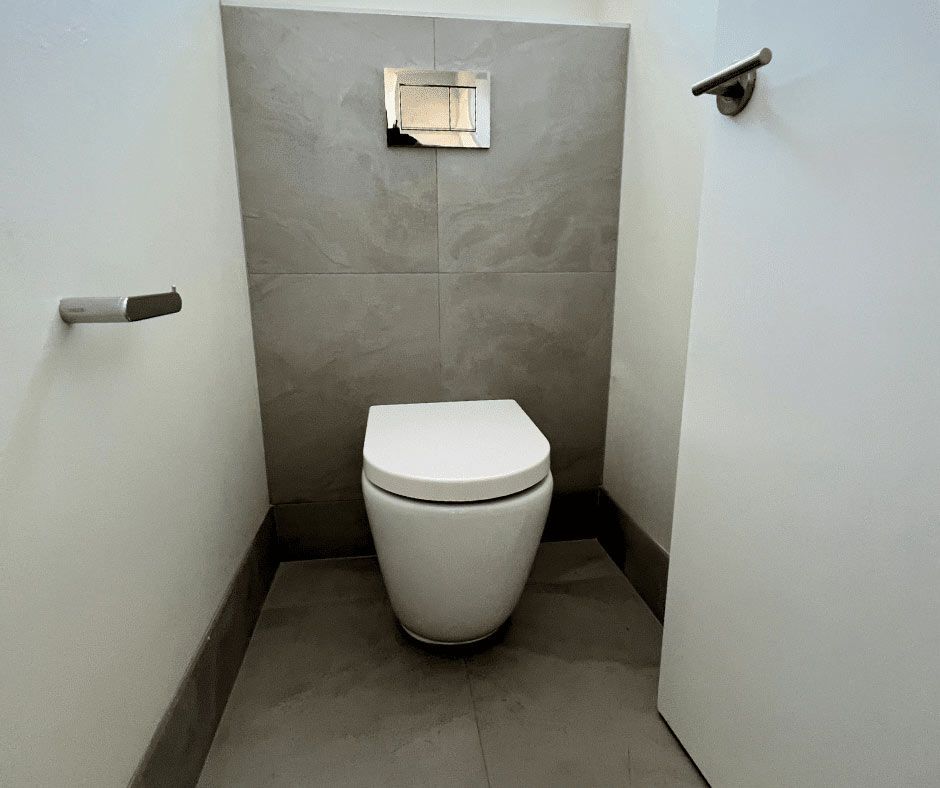 A Toilet Is Sitting In A Small Bathroom — Nyblad Construction in Caloundra West, QLD