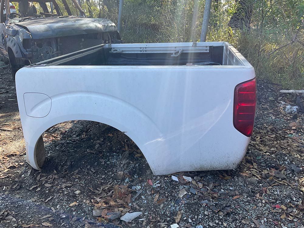 A White Truck Bed Is Sitting On Top Of A Pile Of Dirt — Bago Auto Dismantlers in Wauchope, NSW