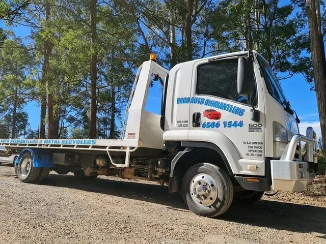 A White Tow Truck Is Parked In A Gravel Area With Trees In The Background — Bago Auto Dismantlers in Wauchope, NSW