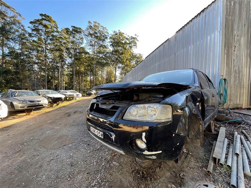 A Black Car With Its Hood Up Is Parked In Front Of A Building — Bago Auto Dismantlers in Wauchope, NSW