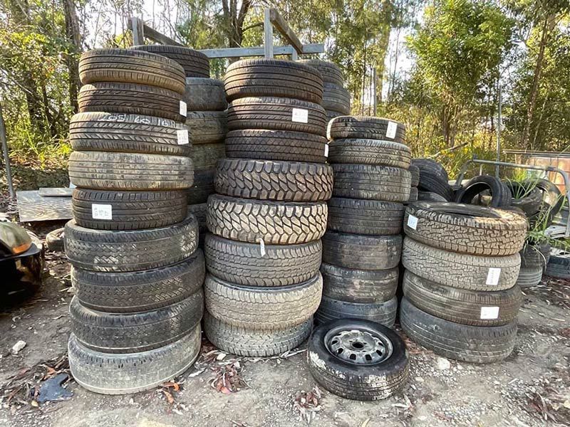 A Pile Of Old Tires Stacked On Top Of Each Other — Bago Auto Dismantlers in Laurieton, NSW