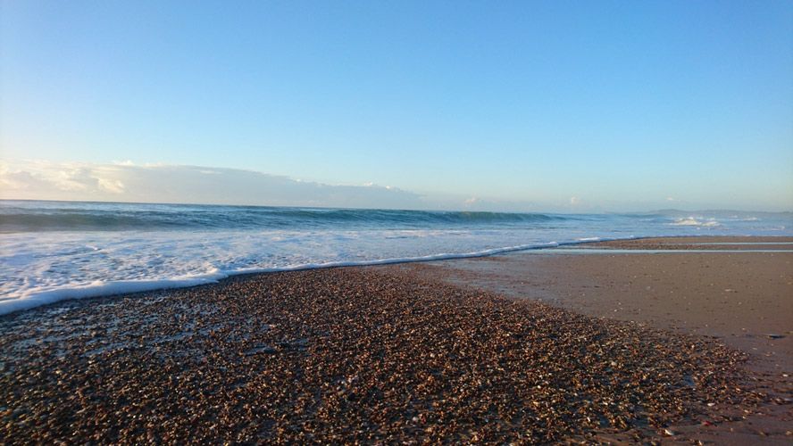 A Beach With Waves Crashing Against The Shore And A Blue Sky In The Background — Bago Auto Dismantlers in Lake Cathie, NSW