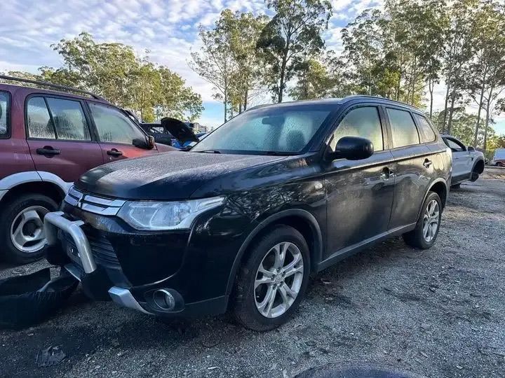 A Black Mitsubishi Outlander Is Parked In A Parking Lot Next To Other Cars — Bago Auto Dismantlers in Lake Cathie, NSW