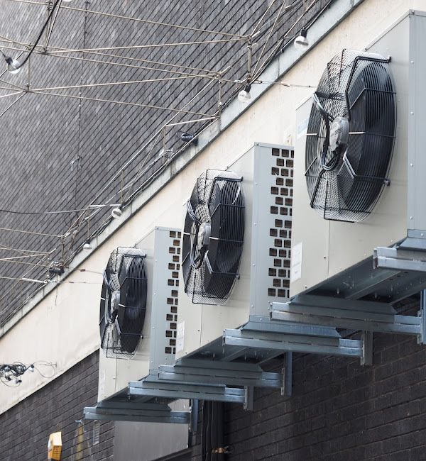 A row of fans on the side of a building