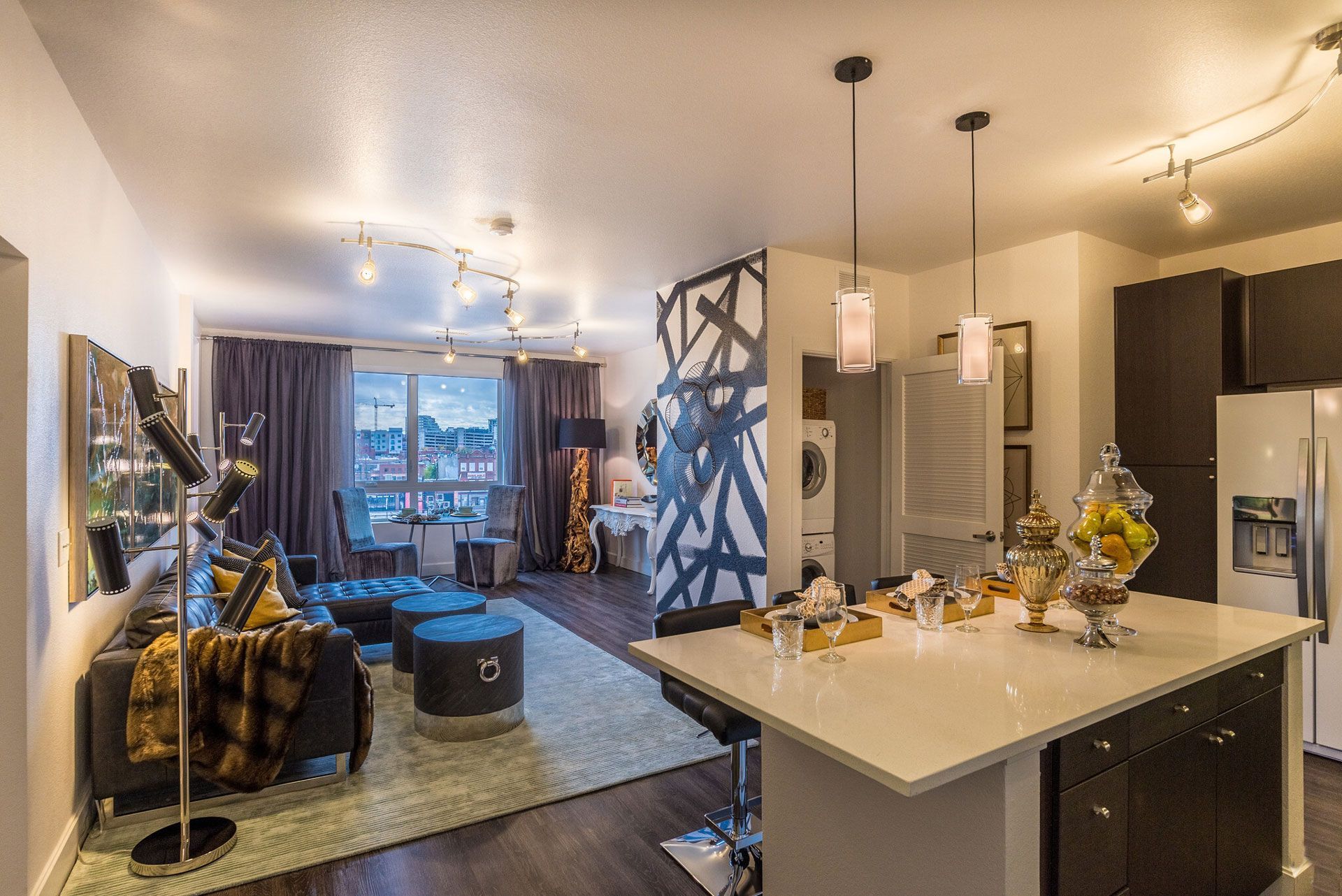 Open-concept living area with a kitchen island and a large city-view window.
