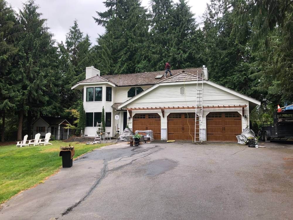 A man is working on the roof of a house.