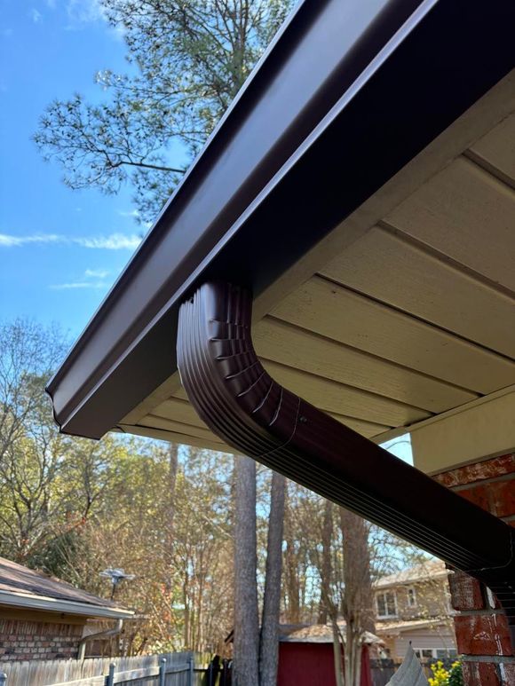 A close up of a gutter on the side of a house.