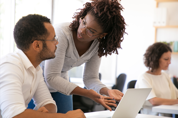 Un homme et une femme regardent un ordinateur portable.