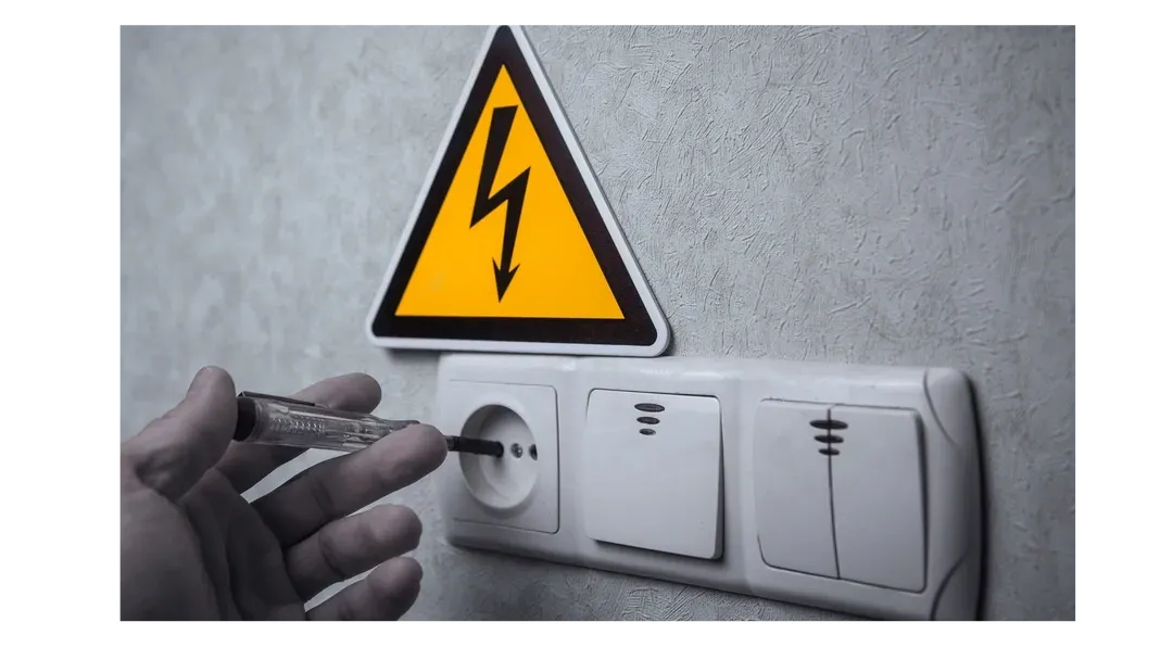 Une personne branche un tournevis sur une prise électrique.