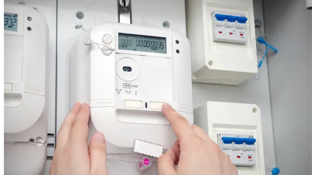 Une personne tient un compteur intelligent dans ses mains.
