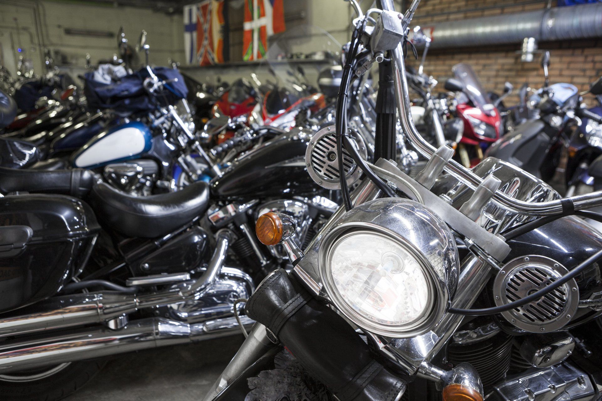 Motos garées à l'intérieur, détails noirs et chromés, dans un décor de type garage.