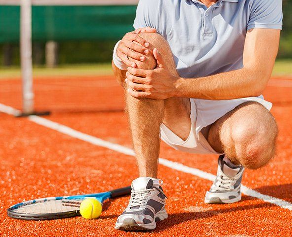 Athlete Holding His Knee — Rose Hill, KS — Rose Hill Chiropractic