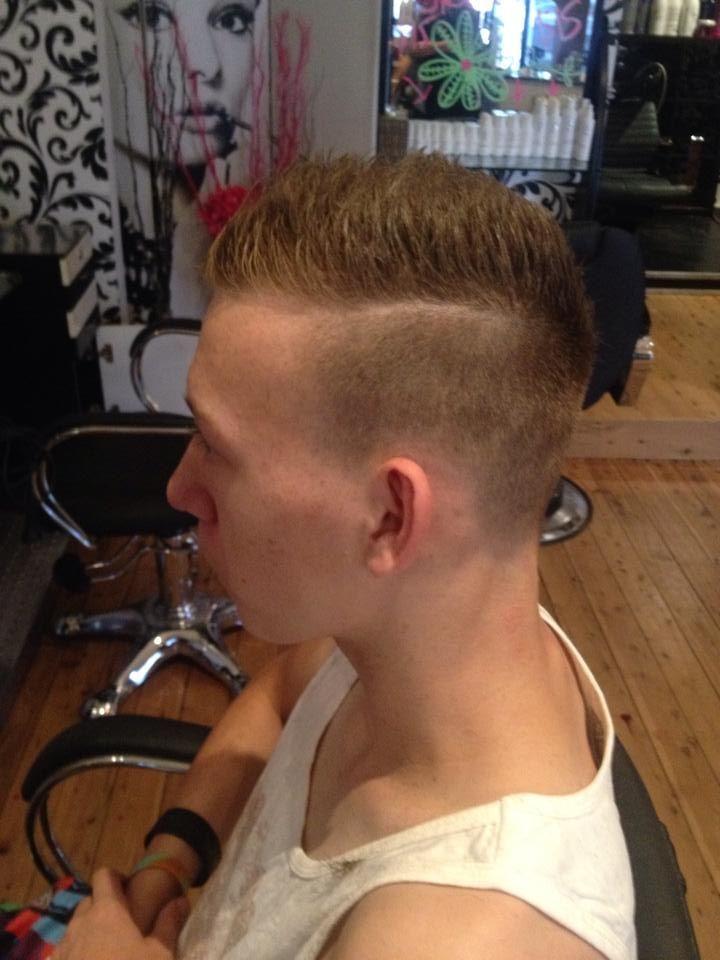 A Man in a White Tank Top is Sitting in a Chair With His Hair Cut — Choo Choo Hair and Beauty In Wyong, NSW