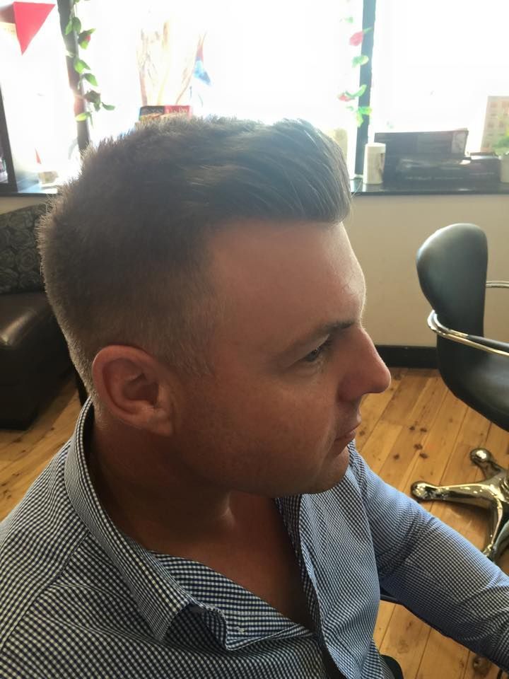 A Man in a Blue Shirt is Sitting in a Chair in a Room — Choo Choo Hair and Beauty In Wyong, NSW