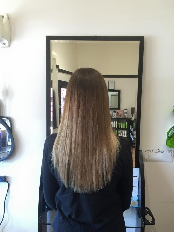 A Woman With Long Hair is Standing in Front of a Mirror — Choo Choo Hair and Beauty In Wyong, NSW