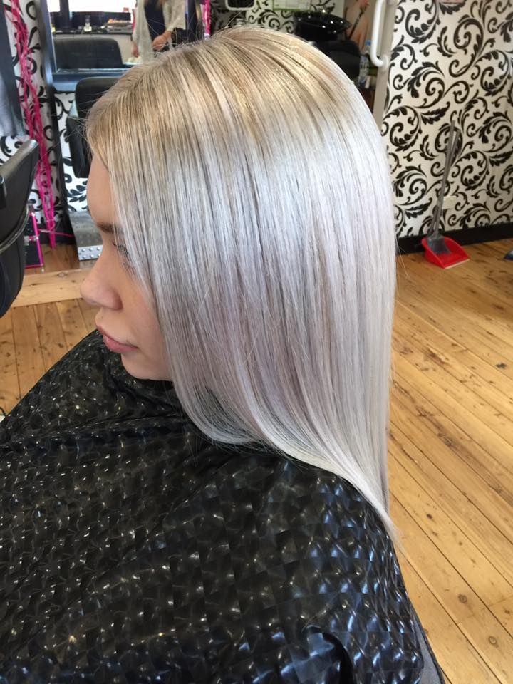 A Woman With Long Blonde Hair is Sitting in a Salon — Choo Choo Hair and Beauty In Wyong, NSW