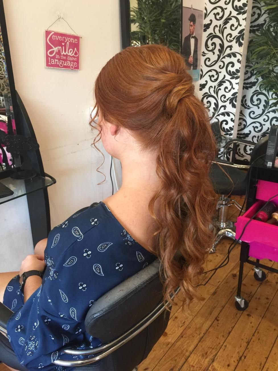 A Woman is Sitting in a Chair With Her Hair in a Ponytail — Choo Choo Hair and Beauty In Wyong, NSW