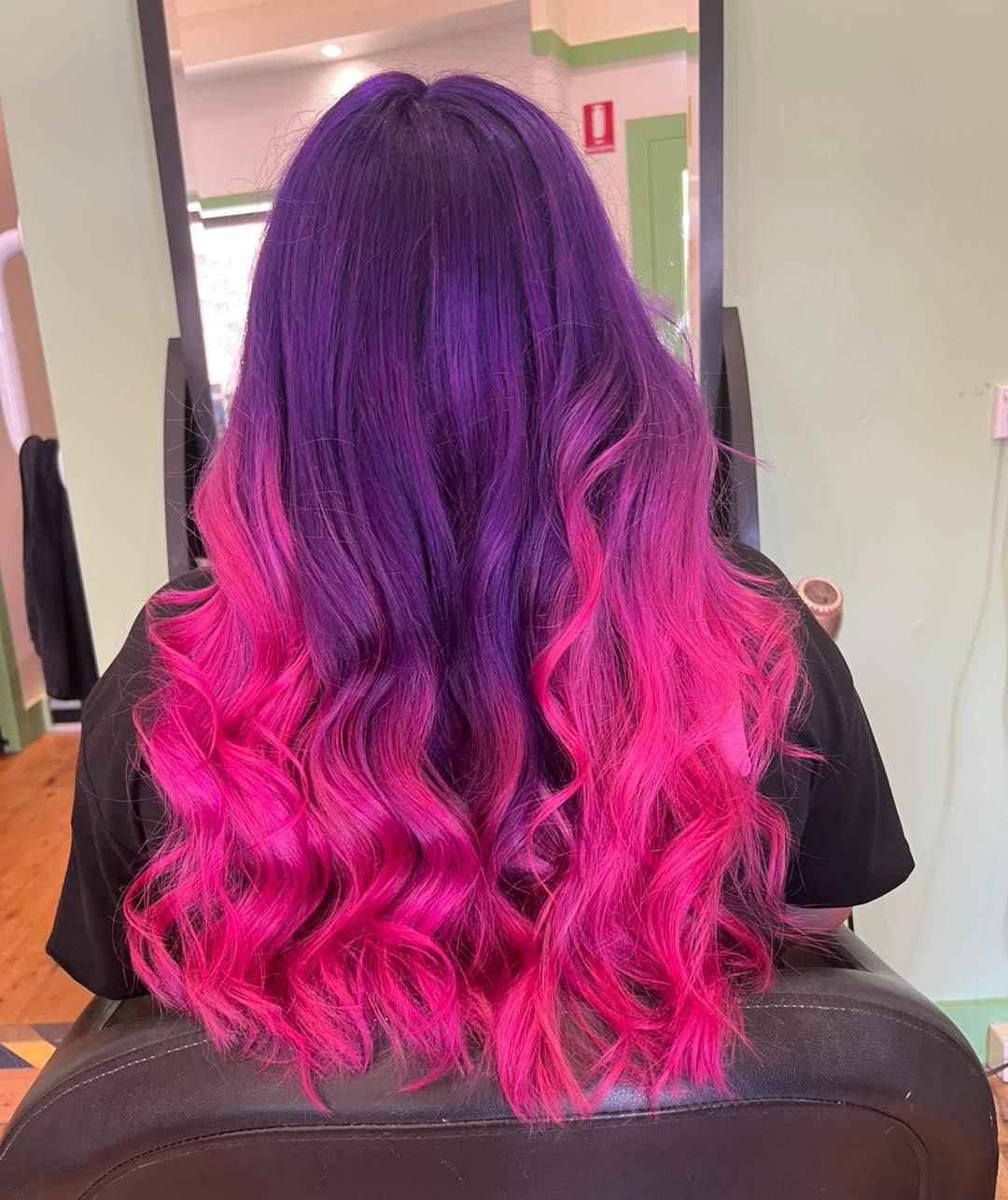 A Woman With Purple and Pink Hair is Sitting in a Chair — Choo Choo Hair and Beauty In Wyong, NSW A Woman With Purple and Pink Hair is Sitting in a Chair — Choo Choo Hair and Beauty In Wyong, NSW