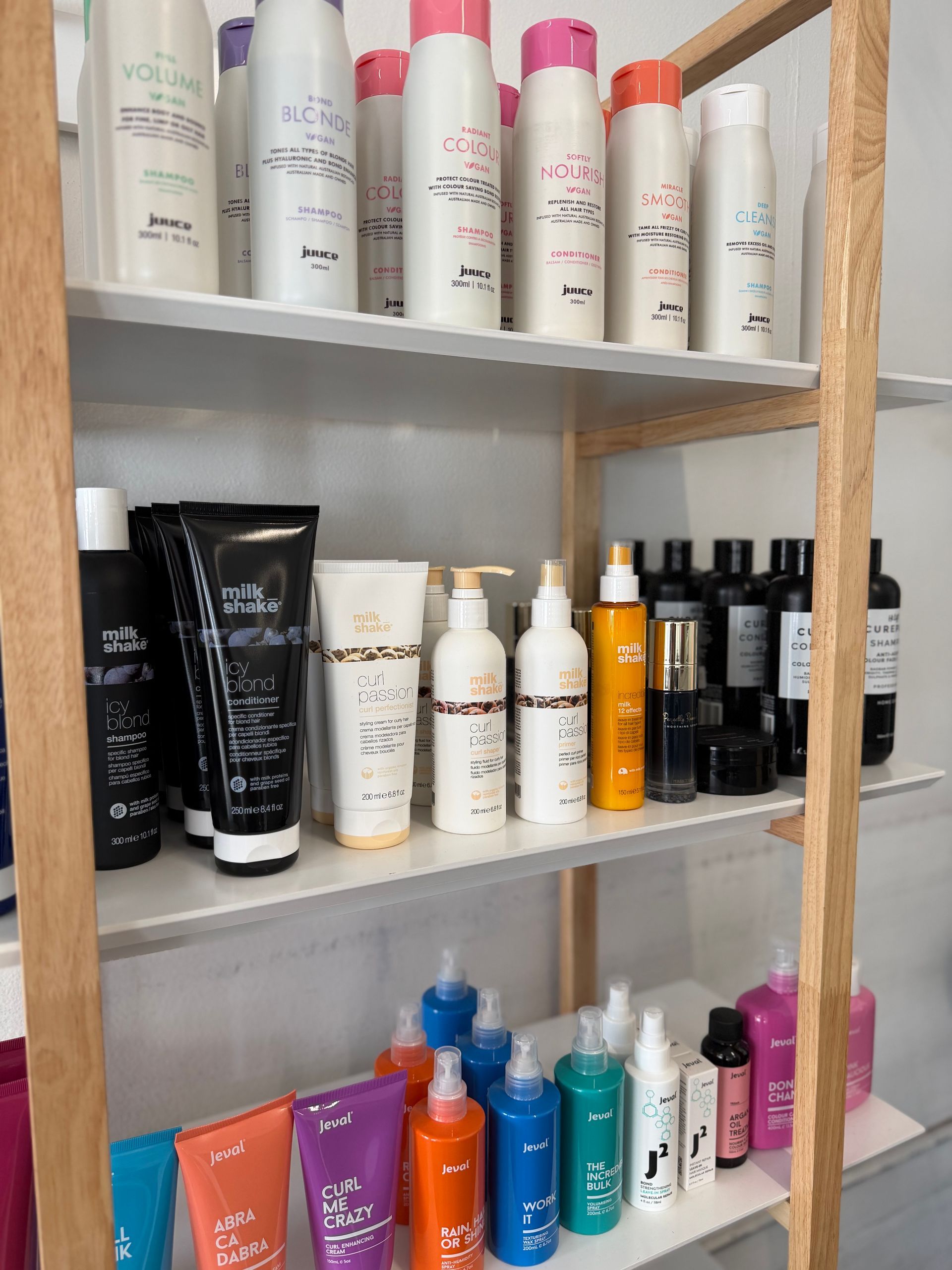 Shelves of assorted skincare and cosmetic bottles in a bathroom or vanity cabinet  — Elysian Salon In Wyong, NSW
