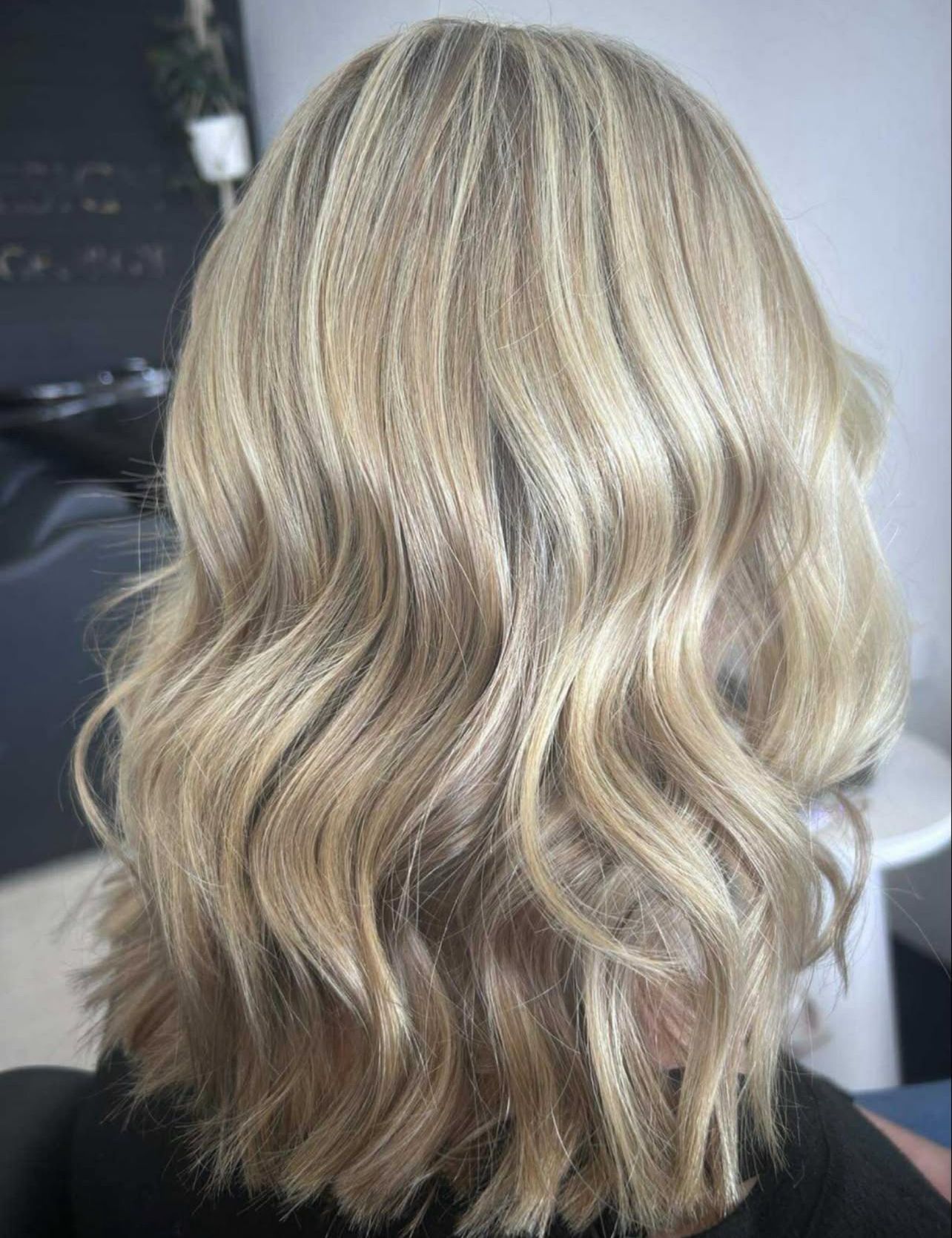 Curly brown hair with pink ombré highlights viewed from behind in a salon chair with a mirror ahead — Elysian Salon In Wyong, NSW