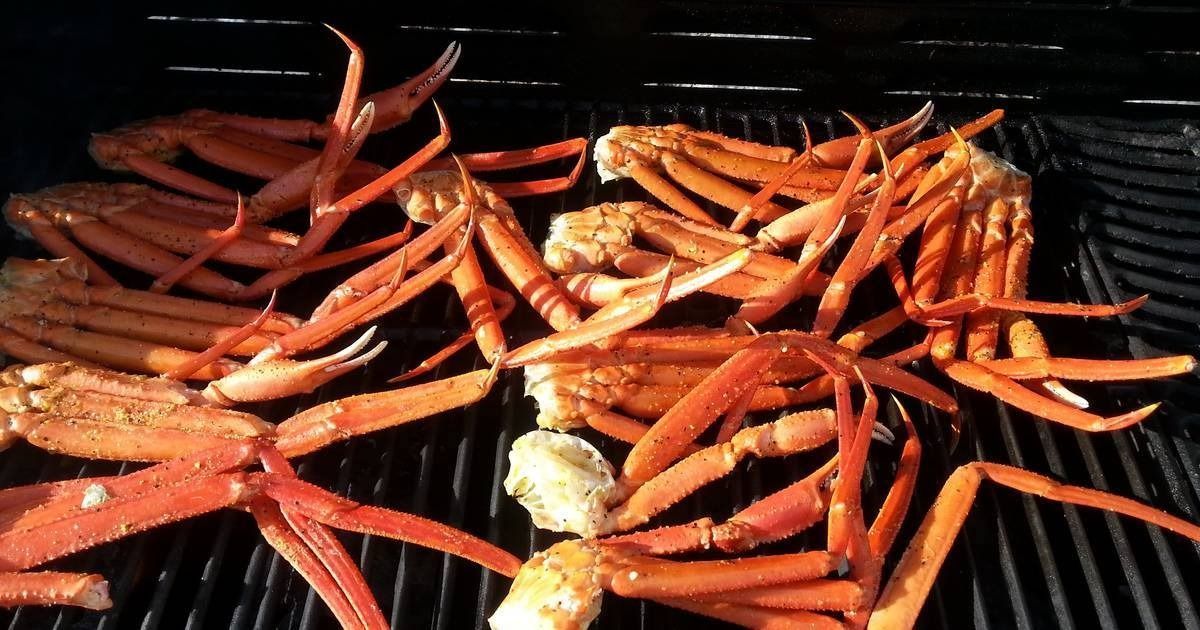 Grilled snow crab legs on a black grill, red and orange colors.