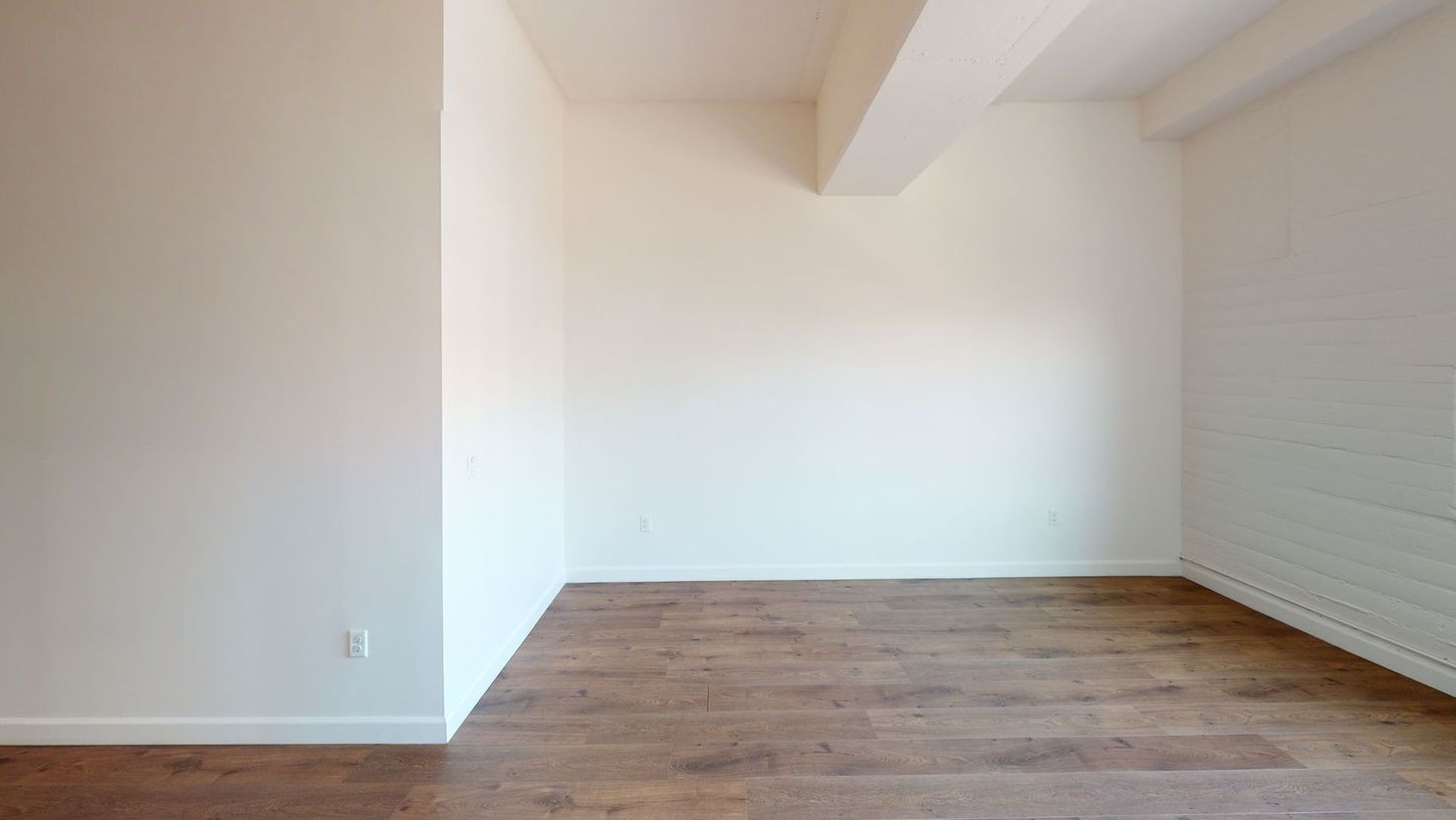 Empty room with hardwood floors and white walls.