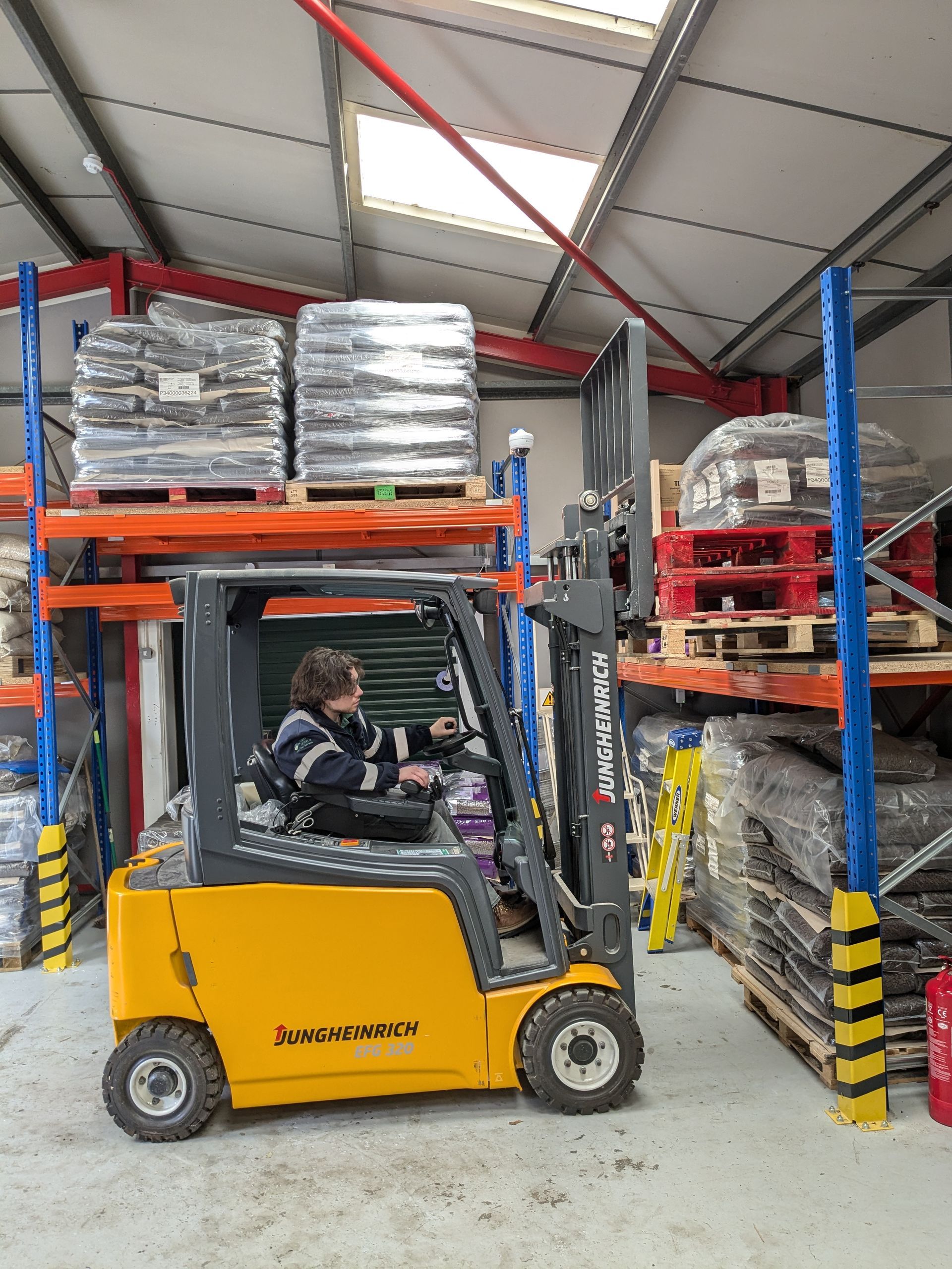 A man is driving a forklift in a warehouse.