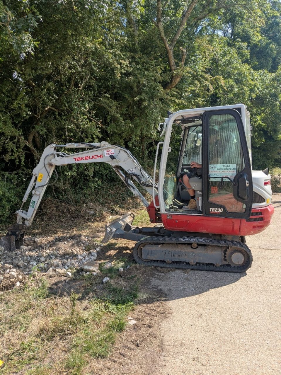 A small excavator is parked on the side of a road.
