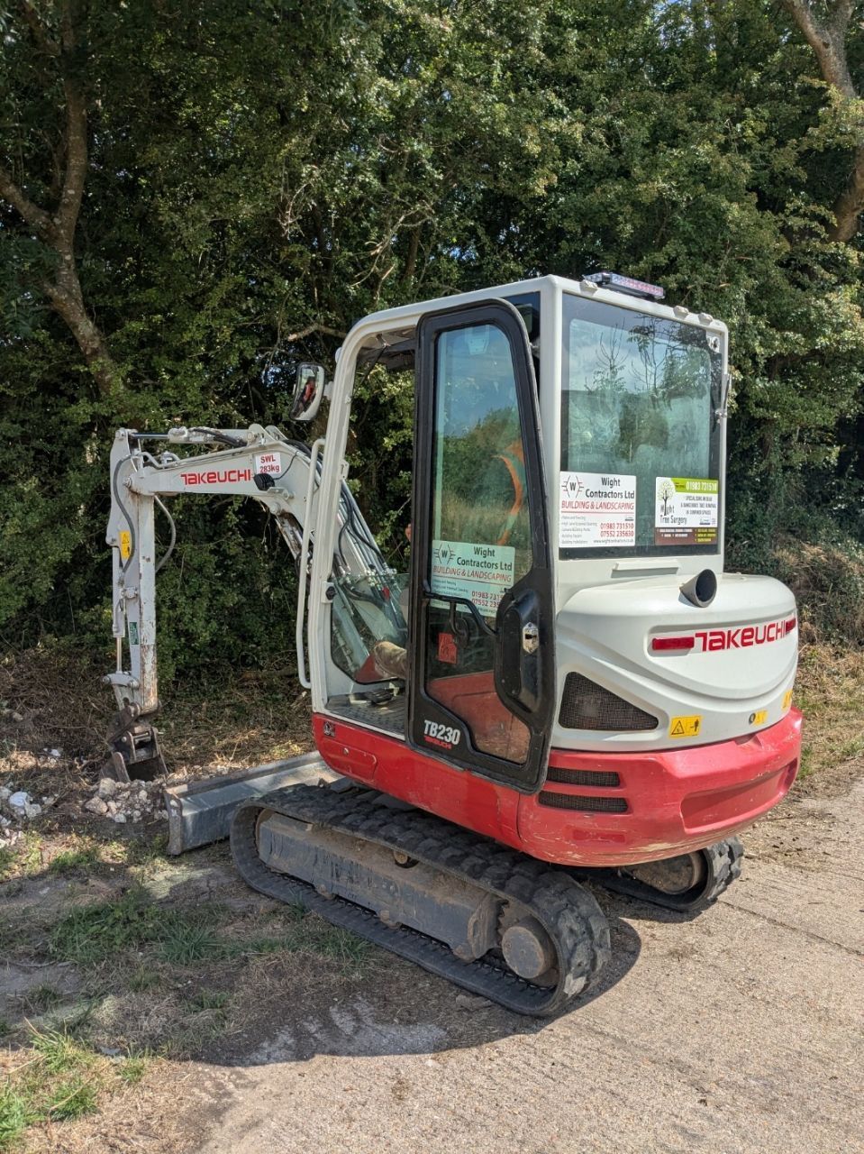 A small excavator is parked on the side of a road.
