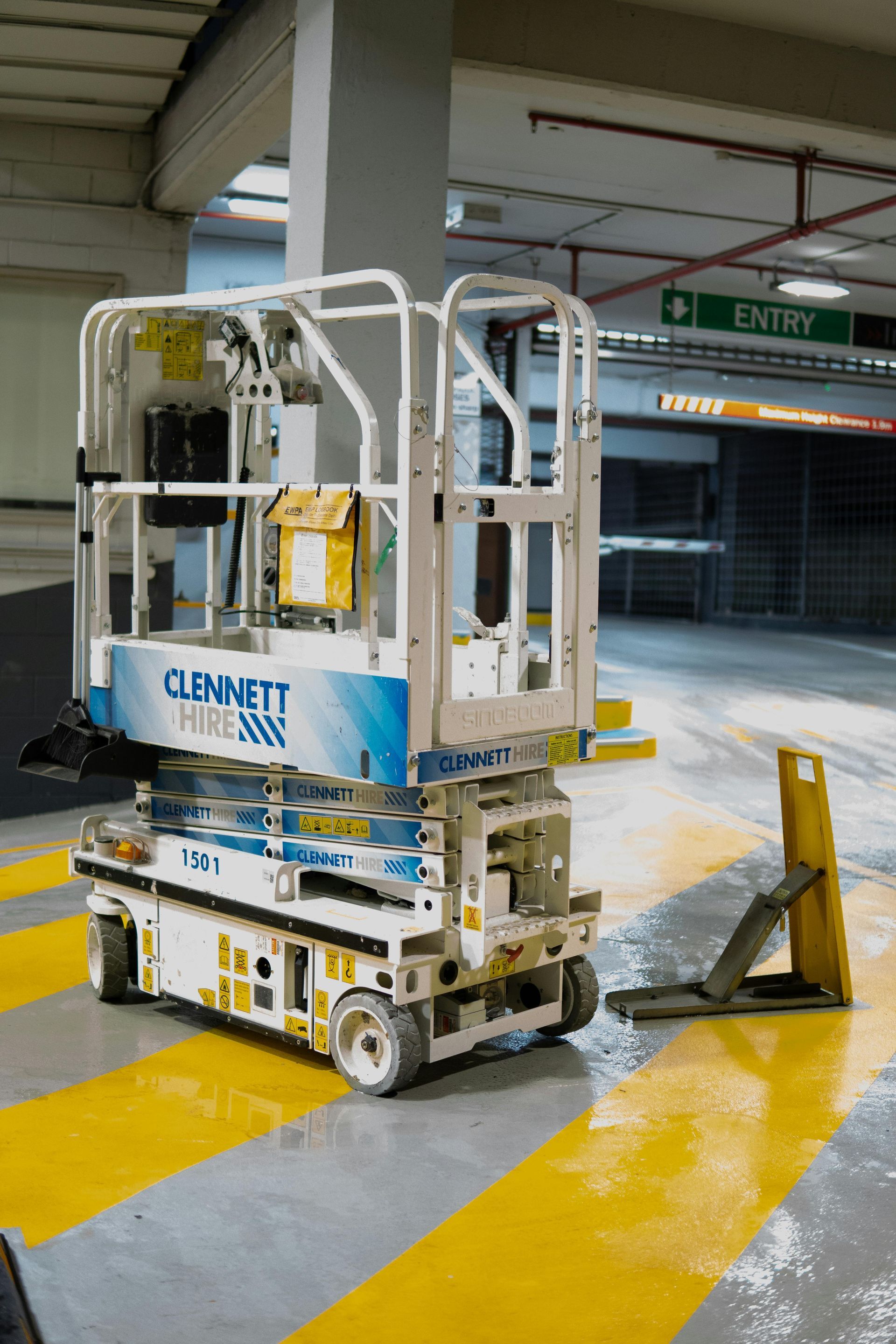A blue and white lift is parked in a parking garage.