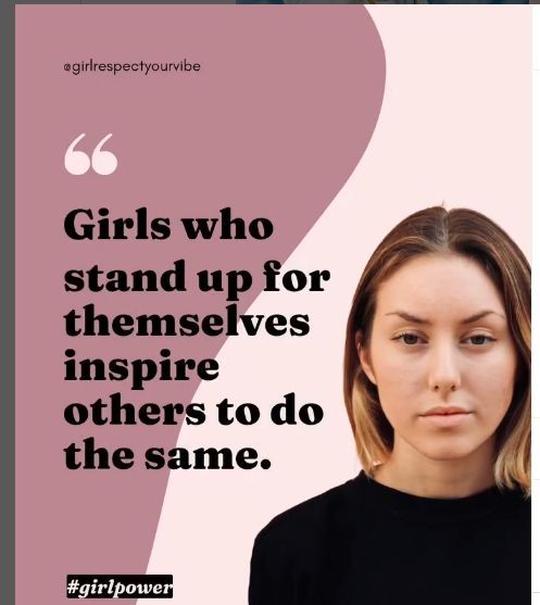 Woman in black leather jacket, white t-shirt, and jeans smiles outdoors with hands in pockets.