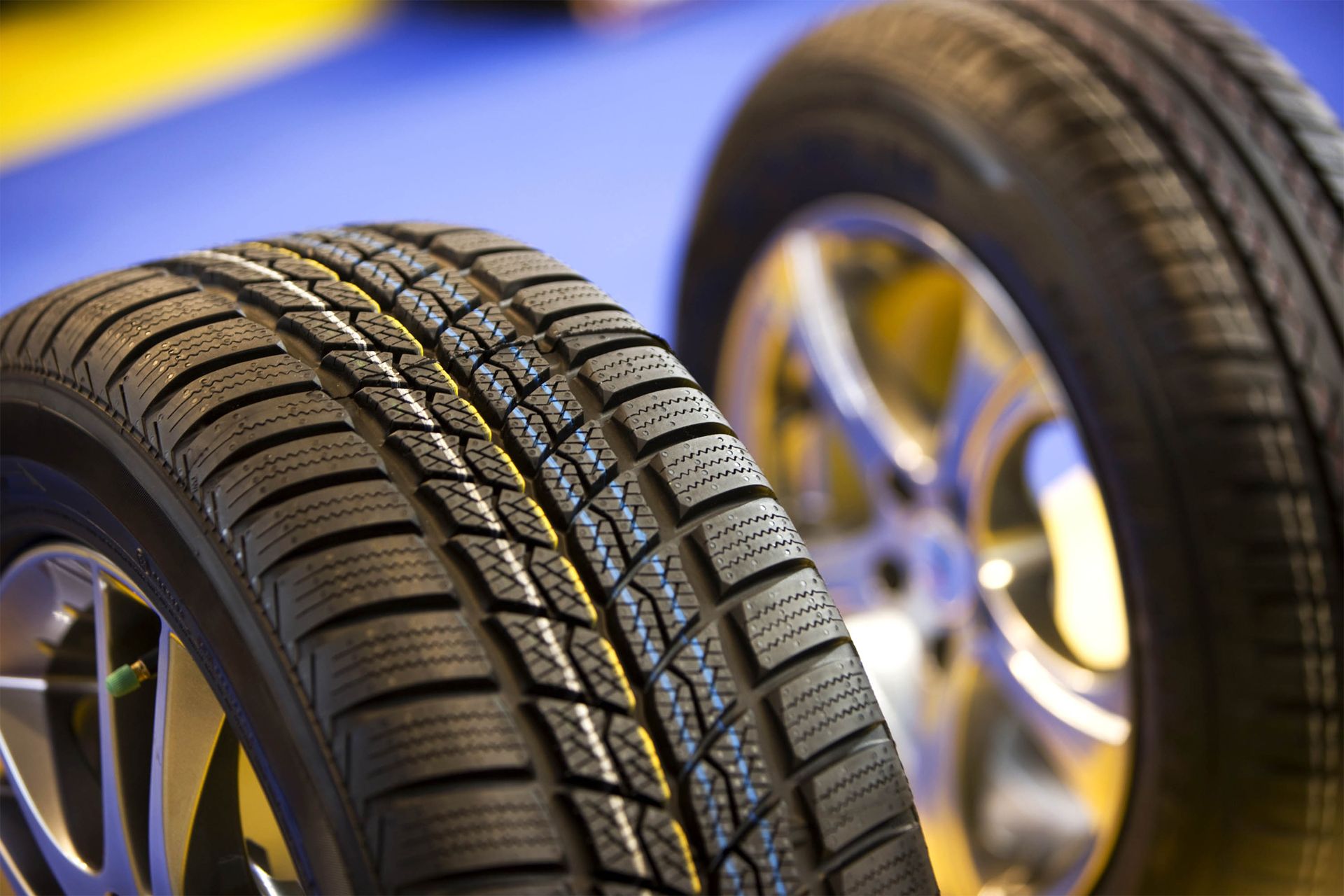 Two tires are sitting next to each other on a blue surface.