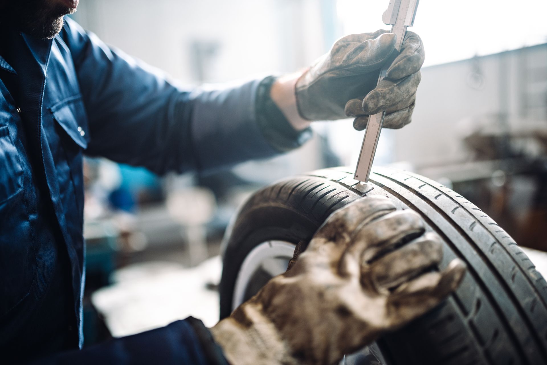 A man is measuring a tire with a tape measure.