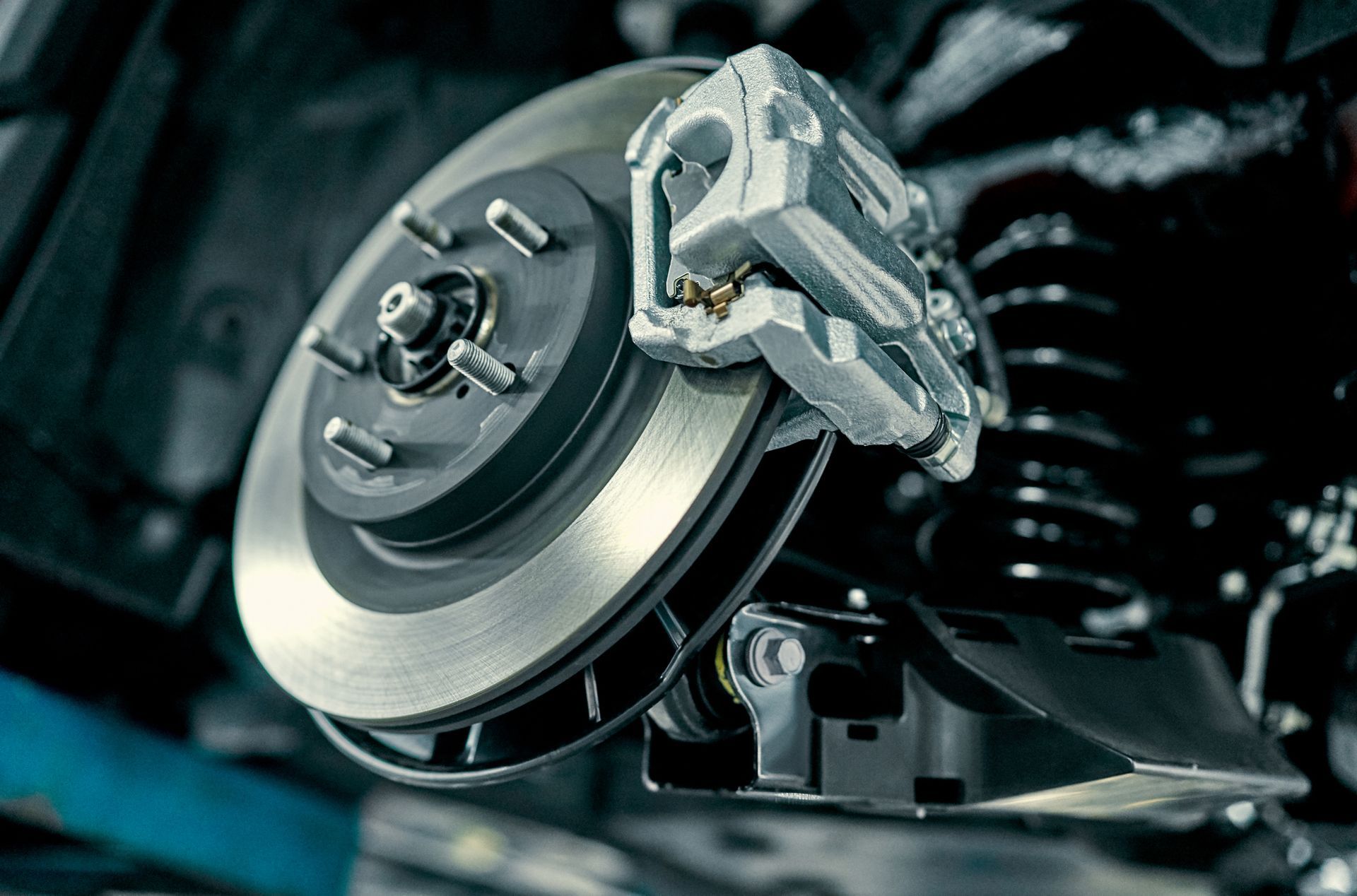 A close up of a brake disc and brake caliper on a car.