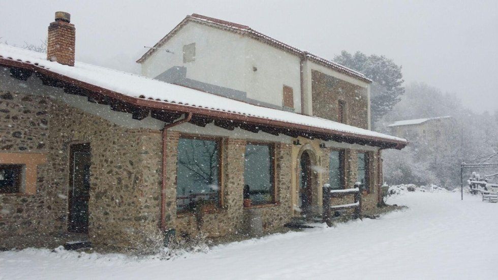 Una casa innevata con un camino sul tetto