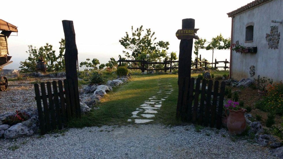 Un cancello di legno conduce a un rigoglioso campo verde