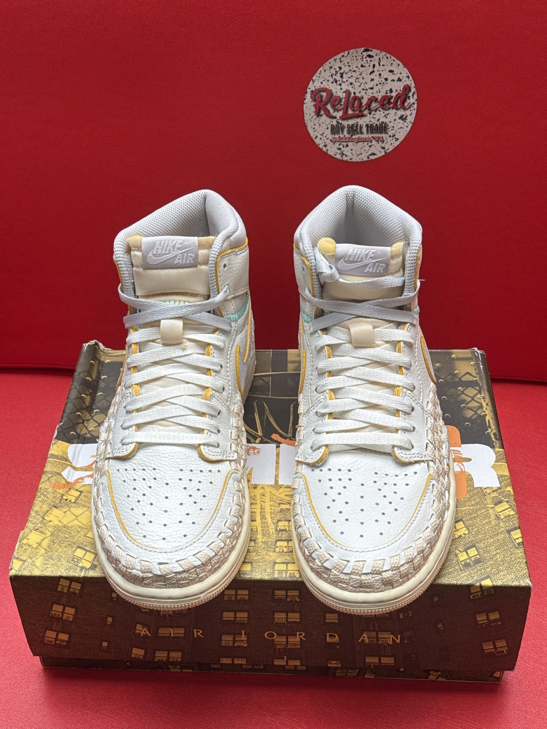 Light blue and yellow high-top sneakers with textured detailing, atop a patterned shoebox.