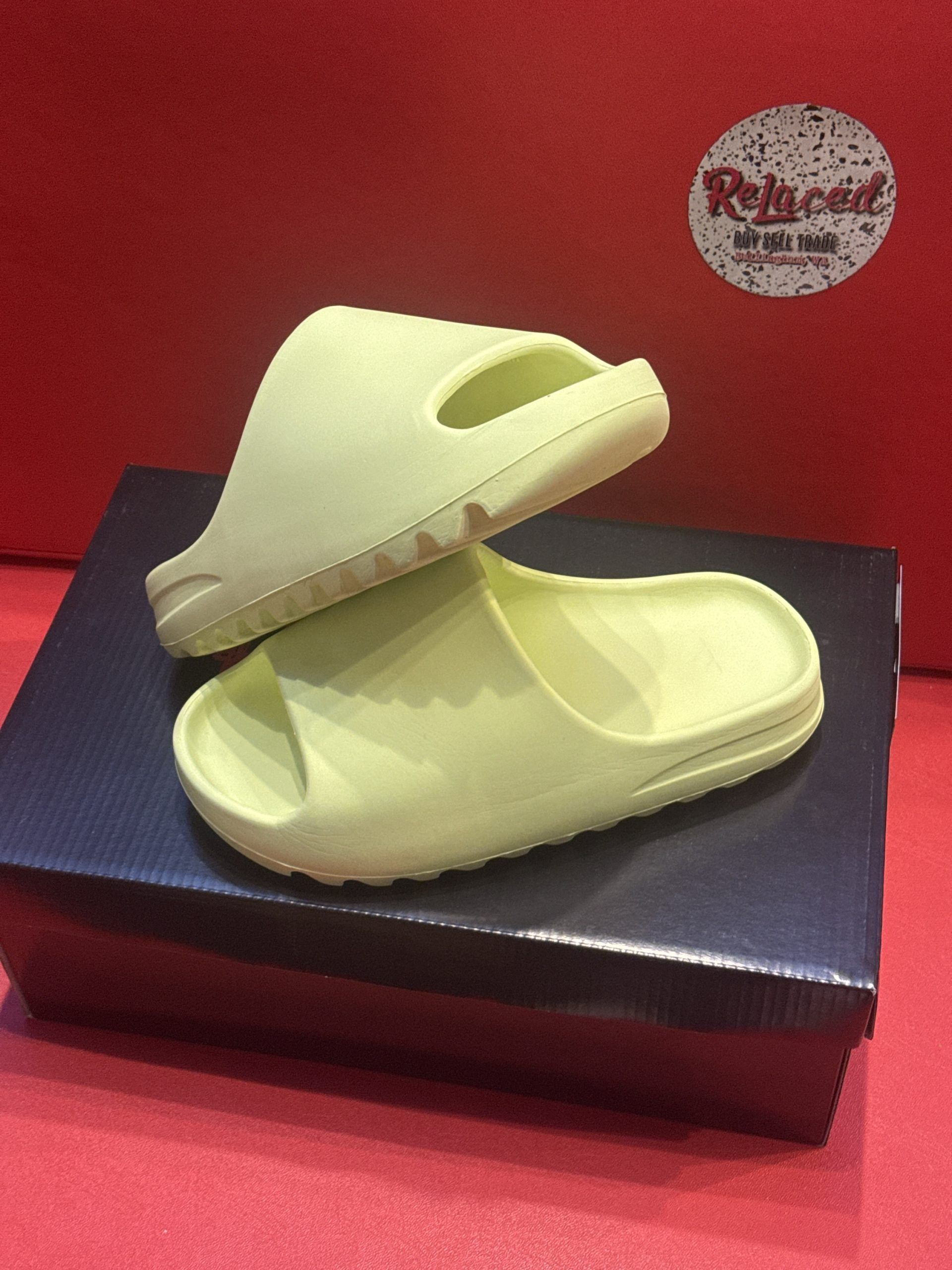 Light green slides on a black box, set against a red background. 