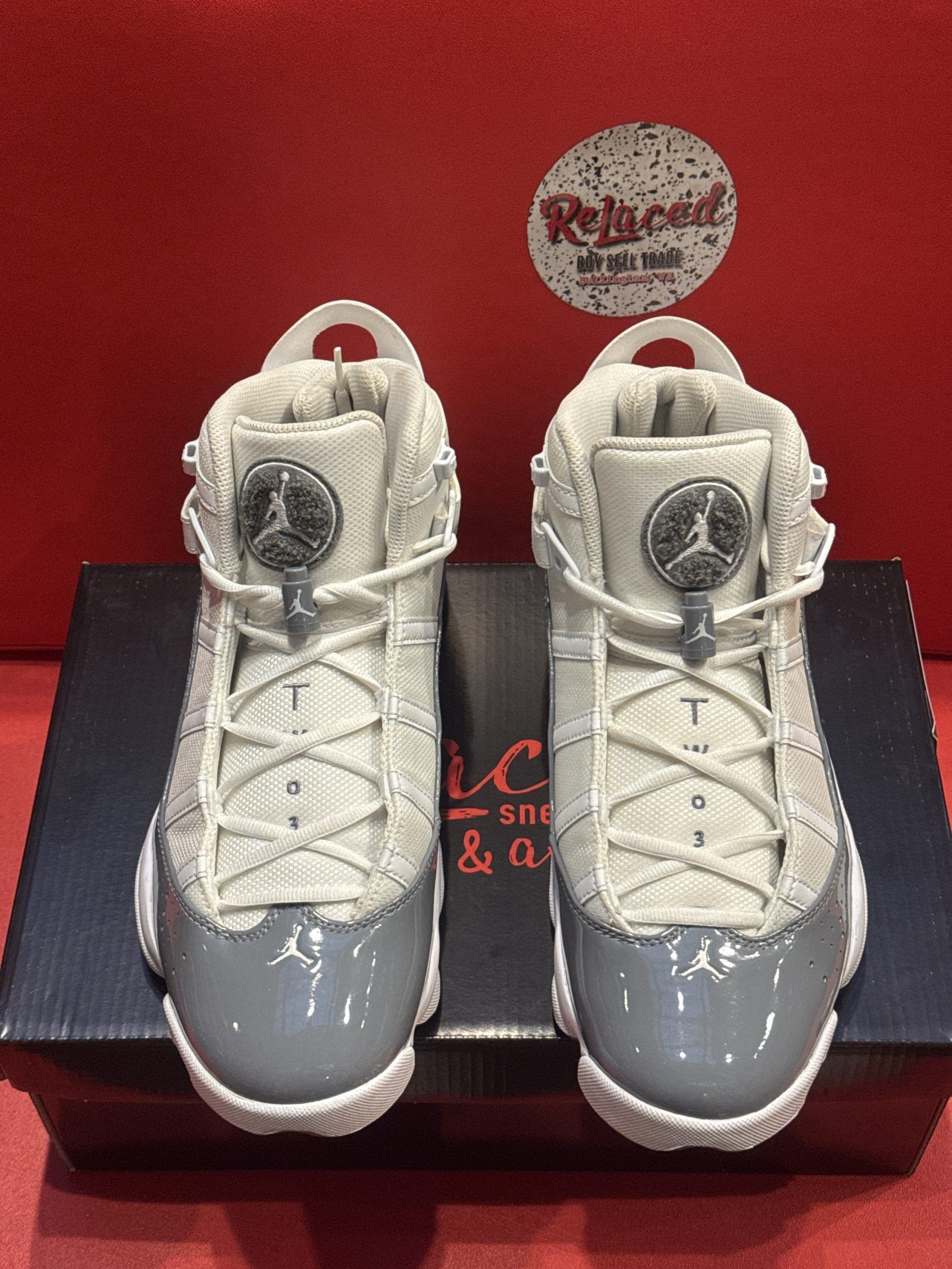 Pair of grey and white Air Jordan sneakers on a shoebox.