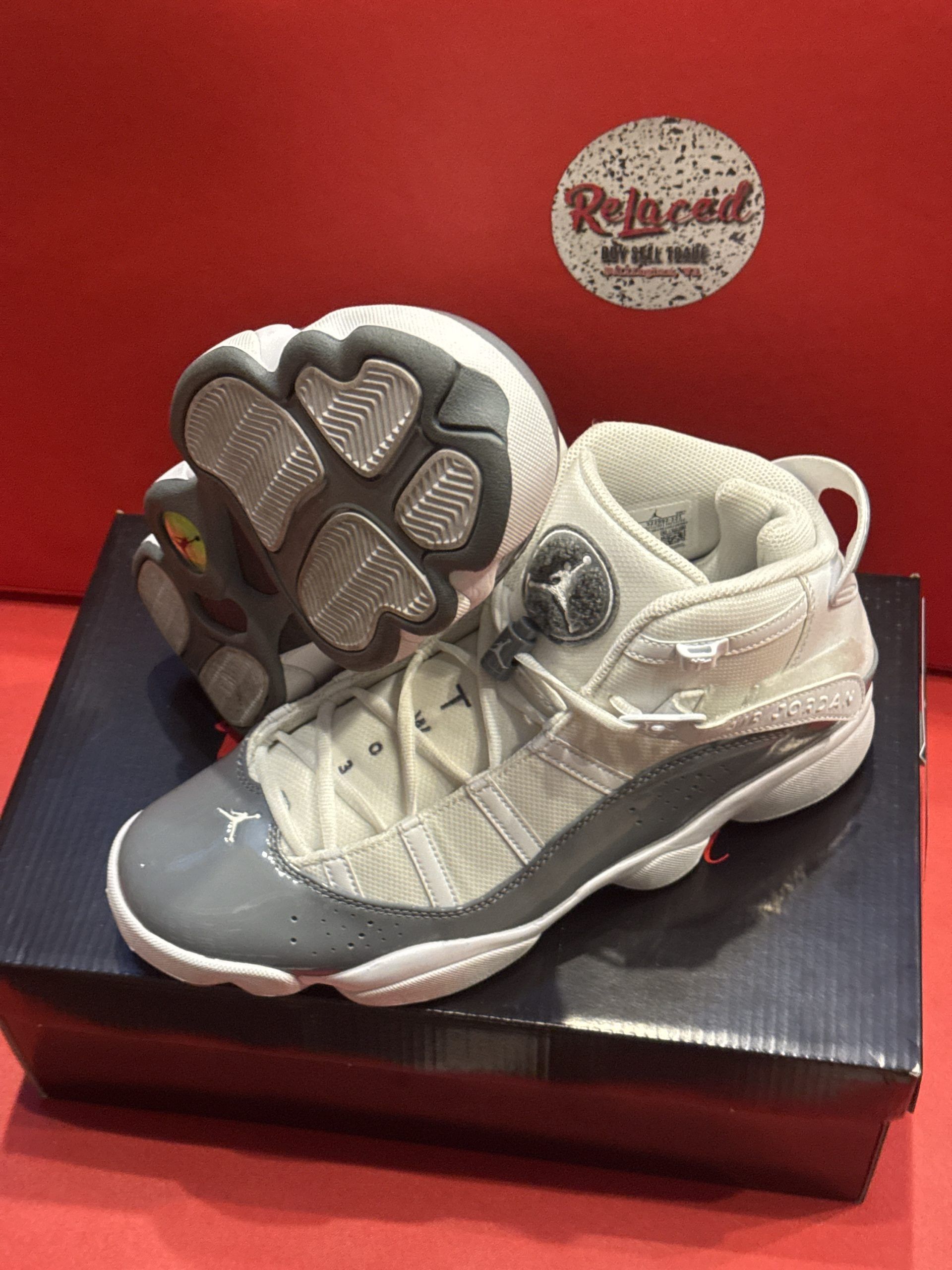Pair of grey and white Air Jordan sneakers on a shoebox.