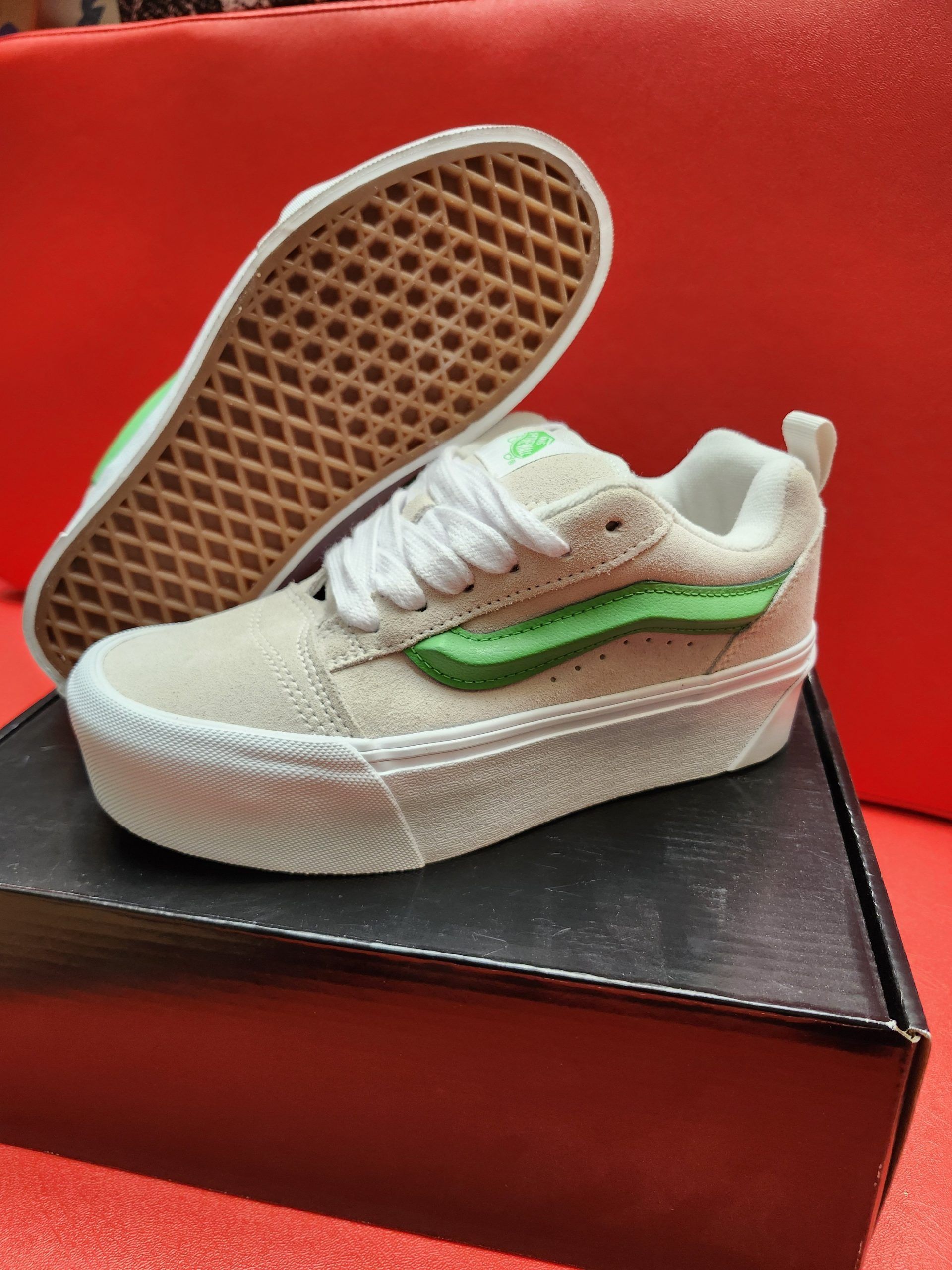 Tan and green Vans sneakers on a white platform sole, with a brown waffle sole.